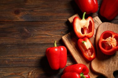 Ahşap arka planda kesilmiş kırmızı dolmalık biber tahtası.