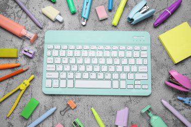 Gri grunge arka planda bilgisayar klavyesi ve okul malzemeleri ile kompozisyon, yakın plan