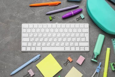 Gri grunge arka planda bilgisayar klavyesi ve okul malzemeleri ile kompozisyon, yakın plan