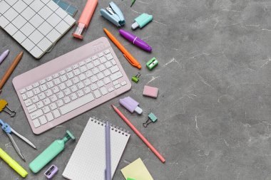 Gri grunge arka planda bilgisayar klavyesi ve okul malzemeleri ile kompozisyon