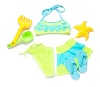 Plaj oyuncaklarıyla çocuk mayosu ve beyaz arka planda parmak arası terlikler.