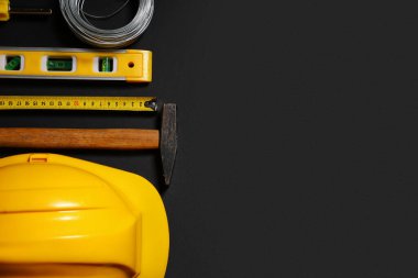 Siyah arkaplan, üst görünüm üzerine sert şapka ve inşaat araçları