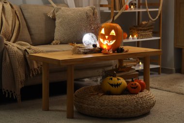 Cadılar Bayramı için dekore edilmiş oturma odasının içi akşamları kanepe, masa ve balkabağı ile süslenir.