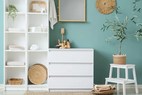 Odanın içinde farklı banyo malzemeleri olan çekmeceler ve raflar.