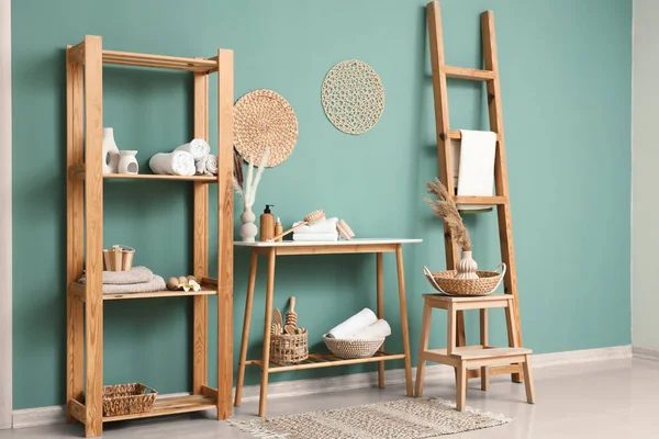 Odanın içinde farklı banyo malzemeleri olan raf ve masa.