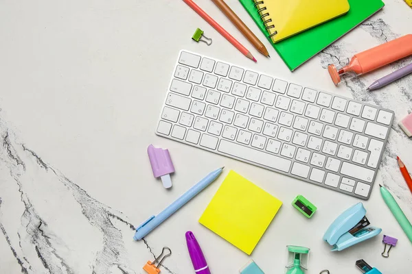 Mermer arka planda bilgisayar klavyesi ve okul malzemeleri ile kompozisyon, yakın plan