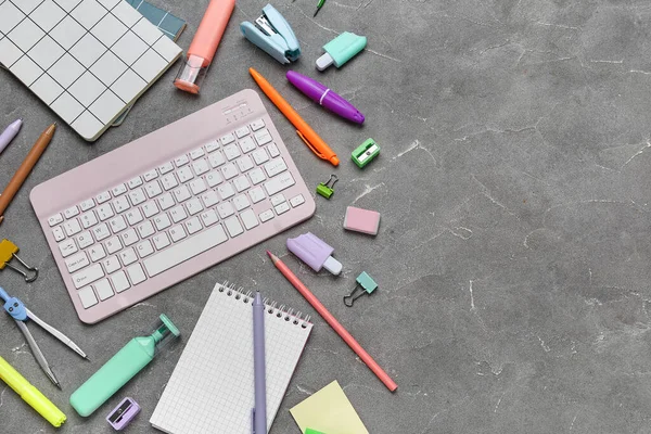 Gri grunge arka planda bilgisayar klavyesi ve okul malzemeleri ile kompozisyon