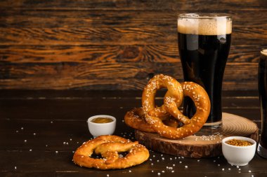 Tahta, kraker ve kahverengi ahşap arka planda koyu bira, yakın plan.