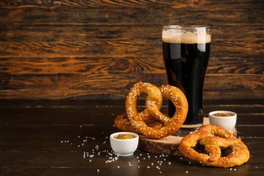 Tahta, kraker ve kahverengi ahşap arka planda koyu bira, yakın plan.