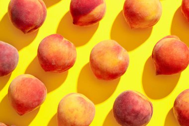 Sarı arka planda olgun şeftaliler