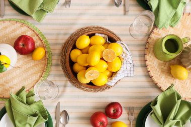 Yemek odasında bir sürü taze limonla dekore edilmiş şık masa seti.