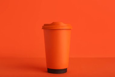 Turuncu masada kahve fincanı var.