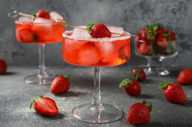 Buzlu bardaklar ve gri grunge arka planda çilekler.
