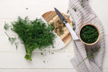 Tahta ve kase, beyaz ahşap arka planda taze yeşil dereotlu.