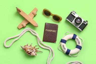 Pasaportlu kompozisyon, fotoğraf makinesi, oyuncak uçak ve yeşil arka planda ip