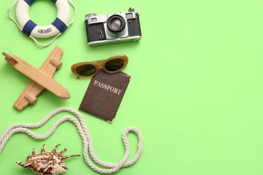 Pasaportlu kompozisyon, fotoğraf makinesi, oyuncak uçak ve yeşil arka planda ip, yakın plan.