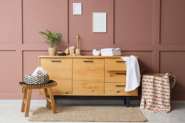 Odanın içinde farklı masaj fırçaları, deniz tuzu, katlanmış havlular ve kahverengi duvarın yanında klozet var.