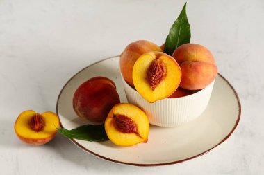 Beyaz arka planda olgun şeftalili tabak ve tabak.