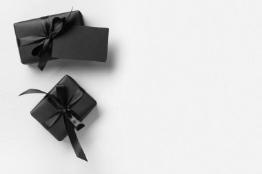 Gri arka planda hediye kutuları olan boş bir siyah kartvizit.