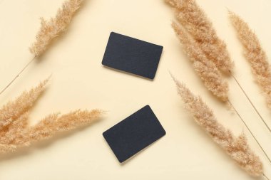 Sarı arka planda kuru sazlıklar olan siyah, boş kartvizitler.