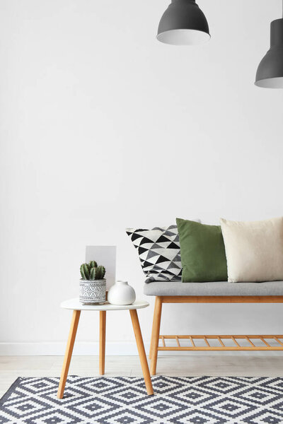 Interior of light room with soft bench, table and lamps