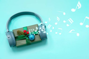 Renkli arka planda Noel hediyesi olan kulaklıklar