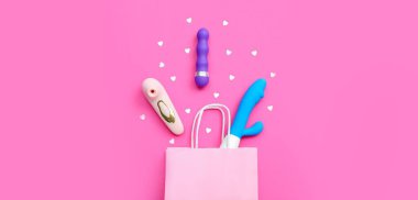 Alışveriş çantası ve pembe arka planda farklı vibratörler. 