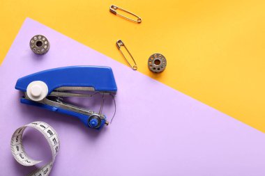 Renk arkaplanında farklı malzemeler olan elle dikiş makinesi