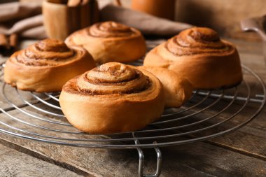 Tahta arka planda tatlı tarçınlı rulolarla dur