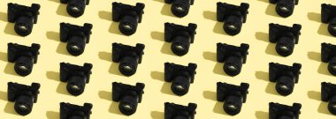 Sarı arka planda birçok modern profesyonel fotoğraf makinesi var. Tasarım için desen