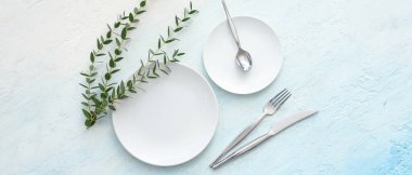 Mavi grunge arka planında okaliptüs dalları olan güzel bir masa. Üst görünüm