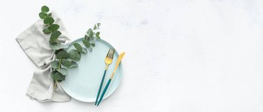 Beyaz grunge arka planında okaliptüs dalları olan güzel bir masa. Üst görünüm