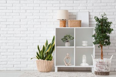 Ev bitkisi, heykel ve raf üniteli aydınlatma odasının içinde.