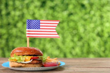 Açık havada Amerikan bayrağı taşıyan lezzetli bir burger, yakın plan. Amerikan Bağımsızlık Günü kutlamaları