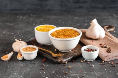 Siyah arka planda sarımsak ve biberli Dijon hardalı.