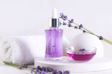 Havlu, alçı standı, şişe ve bir kase lavanta yağı ışık arka planda, yakın plan