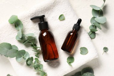 Havlu ve okaliptüs şişeleri hafif arka planda gerekli yağ, yakın plan