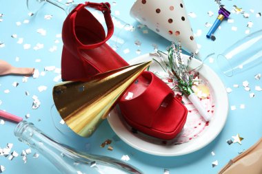 Şık kadın ayakkabısı, kirli tabak ve renkli parti dekoru.