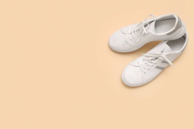 Bej arka planda şık erkek beyaz spor ayakkabıları