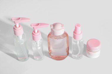 Beyaz arka planda izole edilmiş farklı seyahat kozmetik ürünleri.