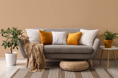 Gri kanepe ve rattan puf ile oturma odasının içinde.