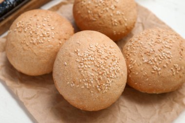 Beyaz ahşap arka planda susam tohumlu taze çörekler pişireceğim.