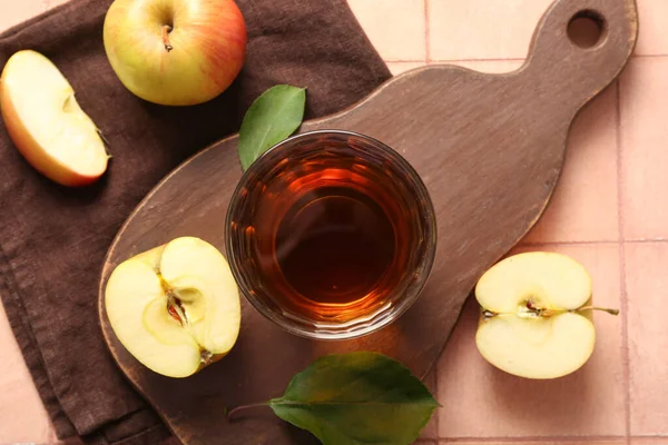 Bej kaplamalı bir bardak taze elma suyu.