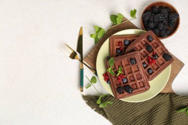 Beyaz arka planda taze böğürtlen ve nane şekerli Belçika Waffle tabağı.