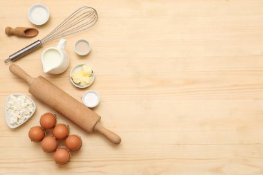 Tahta zemin üzerinde tatlı tarçın rulosu hazırlamak için farklı malzemeler.