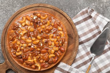 Farklı fındıklı ahşap bir tart tahtası ve gri arka planda karamel.