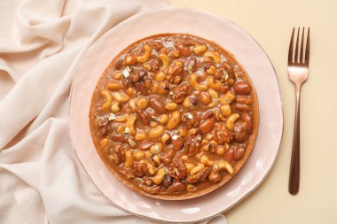 Farklı fındıklı tatlı tart ve bej arkaplanda karamel.