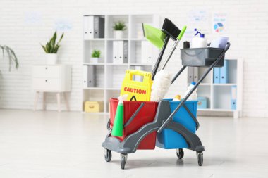 Temizlik malzemeleri ve ikaz levhalarıyla dolu bir servis arabası.