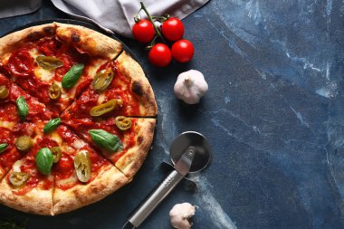 Lezzetli pizzalı kompozisyon, malzemeler ve mavi arka planda kesici.