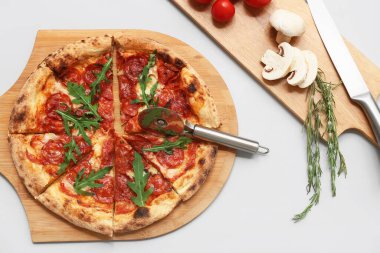 Lezzetli pizzalı kompozisyon, malzemeler ve gri arka planda kesici.